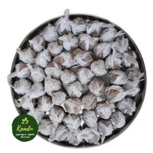 A plate with red rice laddu, a traditional sweet, arranged neatly. The laddu are wrapped in decorative paper, with some pieces visible on the plate.